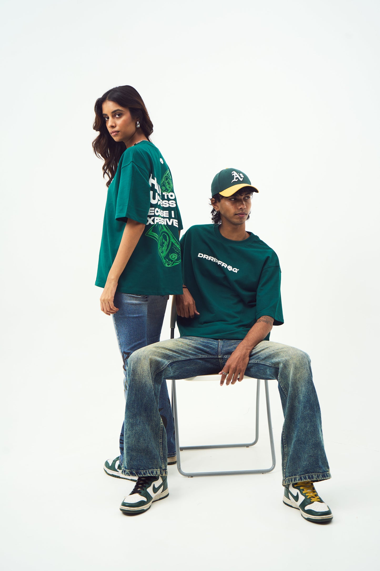 Stylera unisex oversized green t-shirt worn by male and female models styled with jeans sneakers and cap