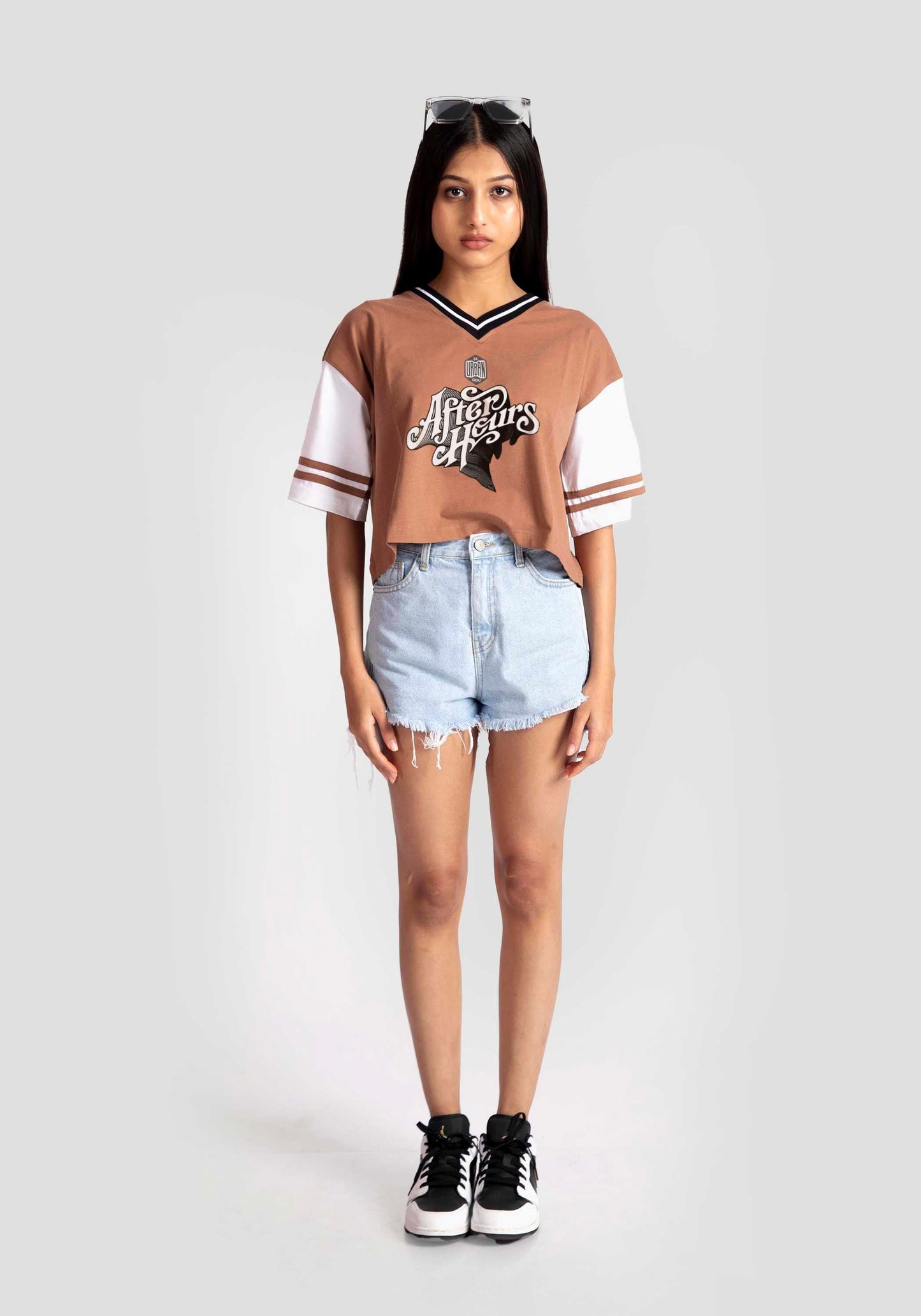 Stylera brown and white graphic tee for women styled with denim shorts and black sneakers