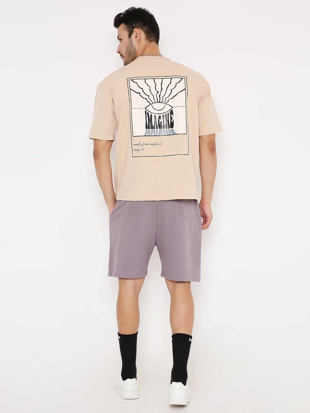 Stylera casual oversized t-shirt with print beige back graphic on male model paired with shorts and sneakers