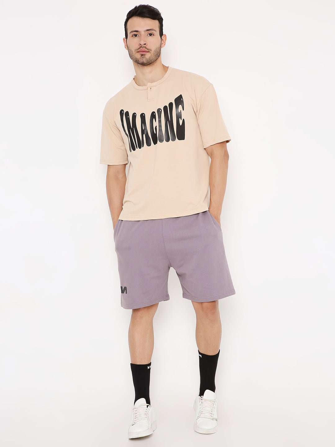 Stylera casual oversized t-shirt with print beige graphic tee on male model paired with purple shorts