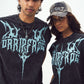 Two models wearing Stylera unisex gothic print sleeveless top in washed black with blue logo
