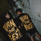 Stylera black graphic t-shirt trendy oversized back print with bold yellow BURN THE REST text worn by two models in gritty hallway