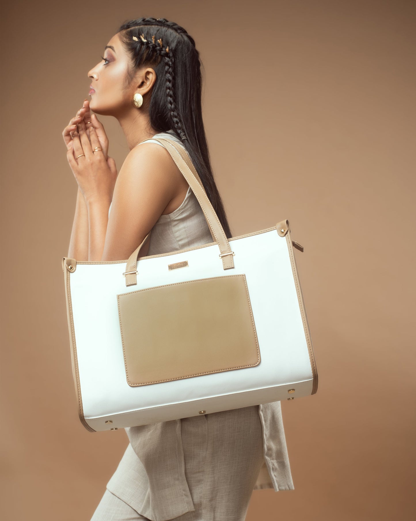 Woman carrying a vanilla taupe box tote bag with elegant design and spacious interior