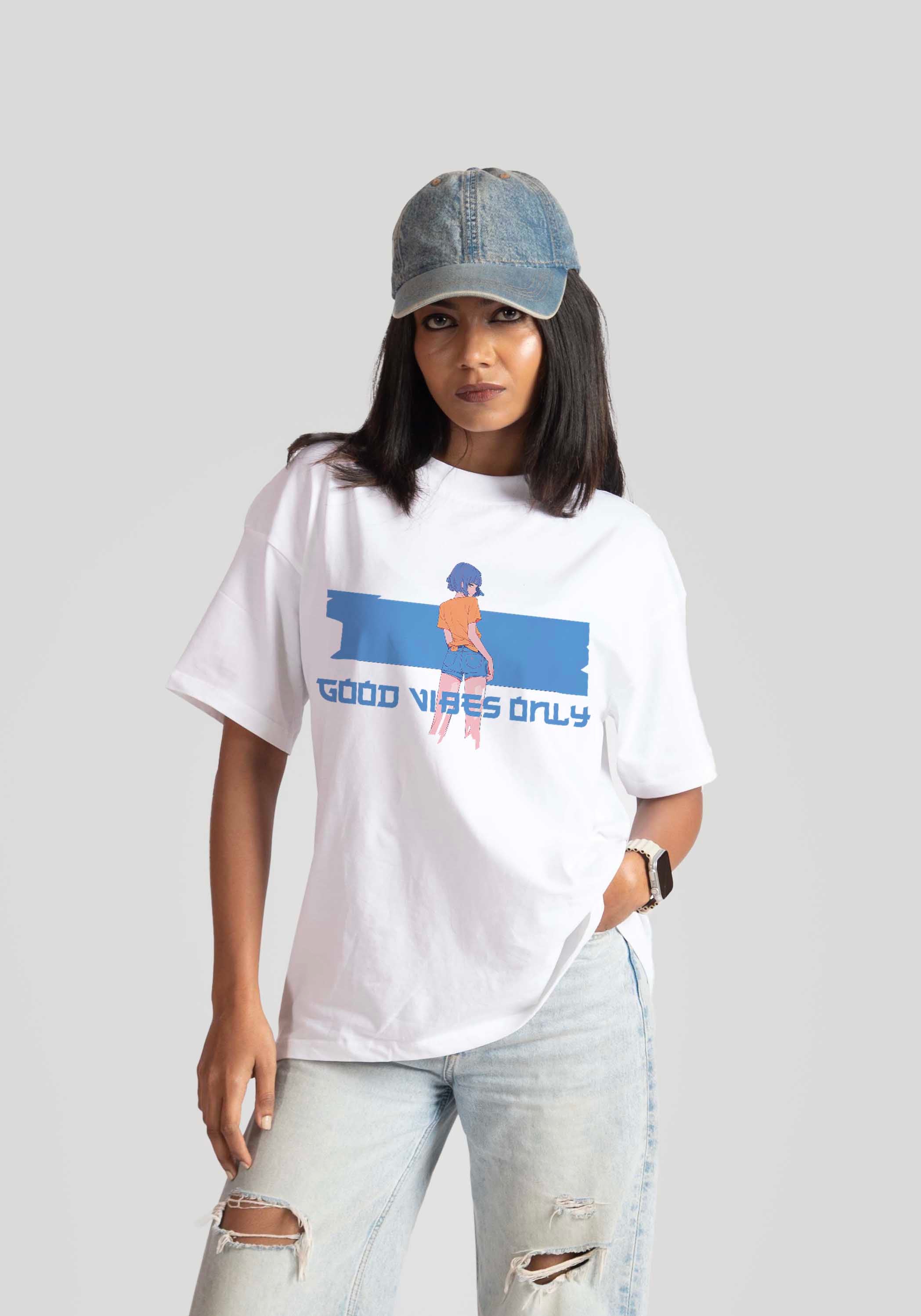 Stylera good vibes only graphic tee for women in white with blue and orange print styled with denim cap and ripped jeans