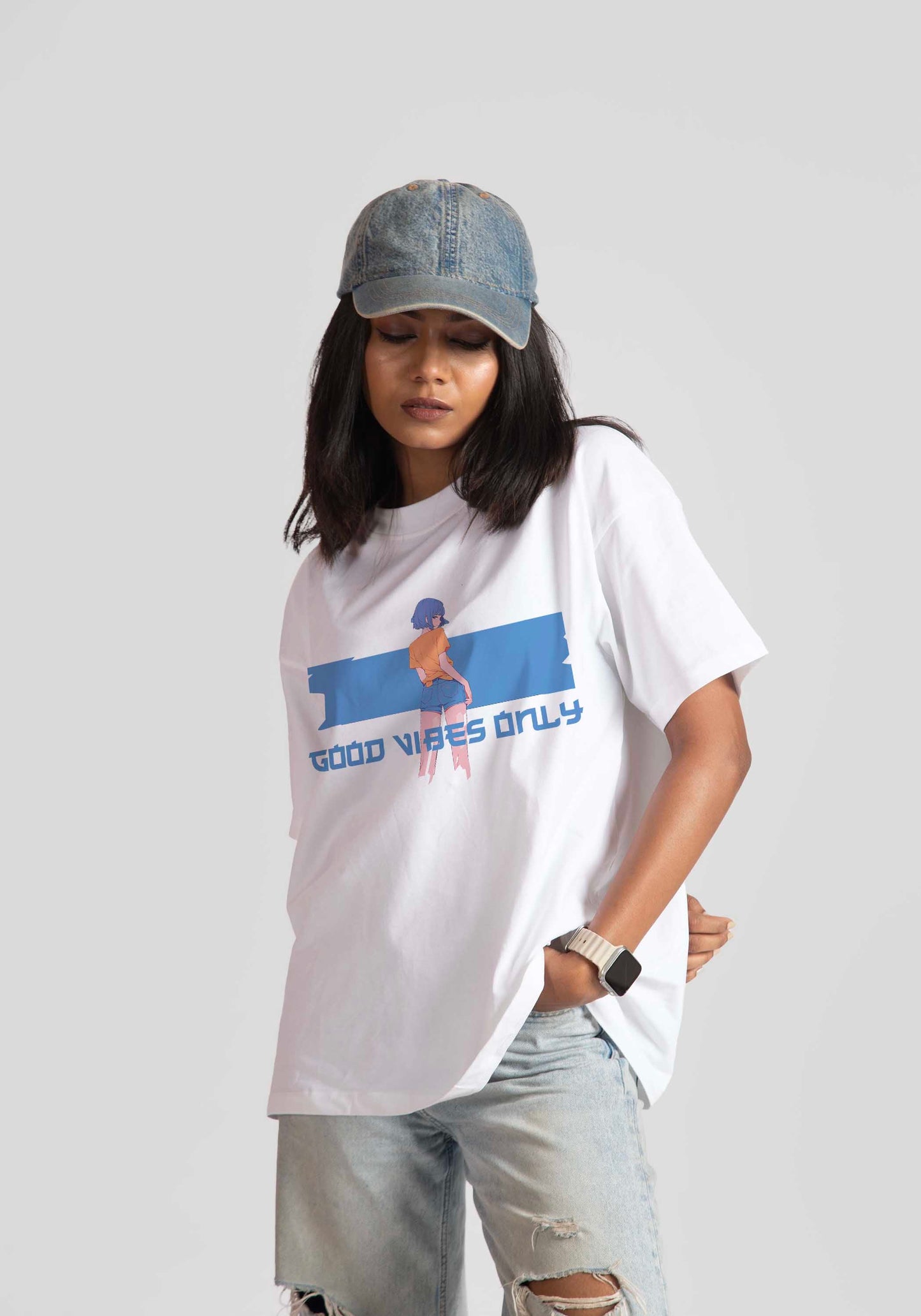 Stylera good vibes only graphic tee for women in white with blue design worn with denim cap and ripped jeans