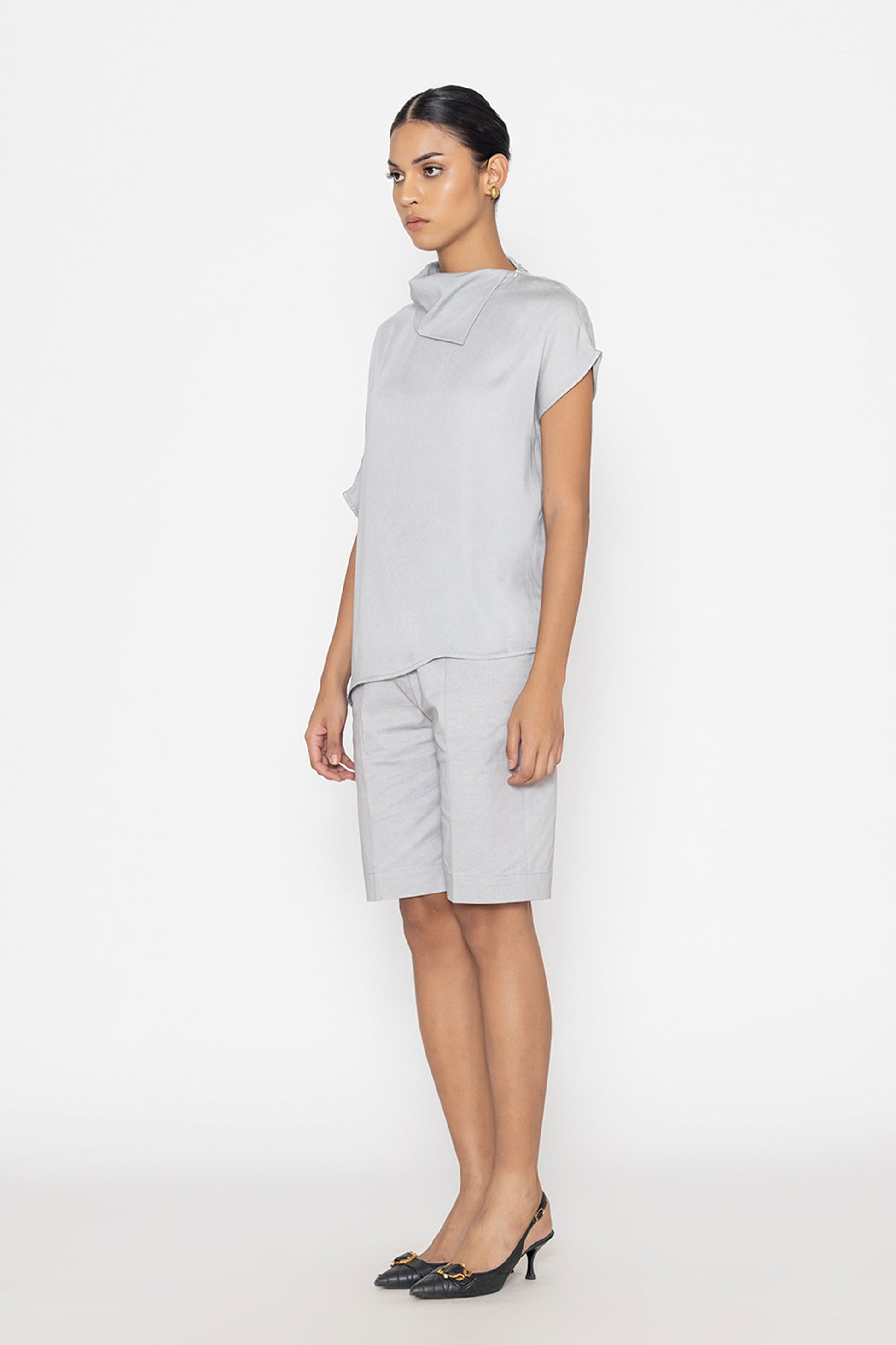 Stylera light gray statement top with short sleeves and asymmetrical collar worn with matching shorts