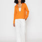 Stylera orange v-neck blouse for women paired with white pants on model