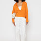 Stylera orange v-neck blouse for women styled with white pants and neutral accessories
