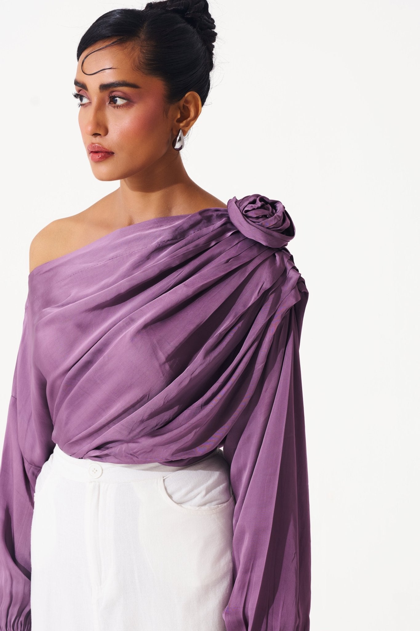 Stylera purple draped evening top with off-shoulder design and floral detail on shoulder