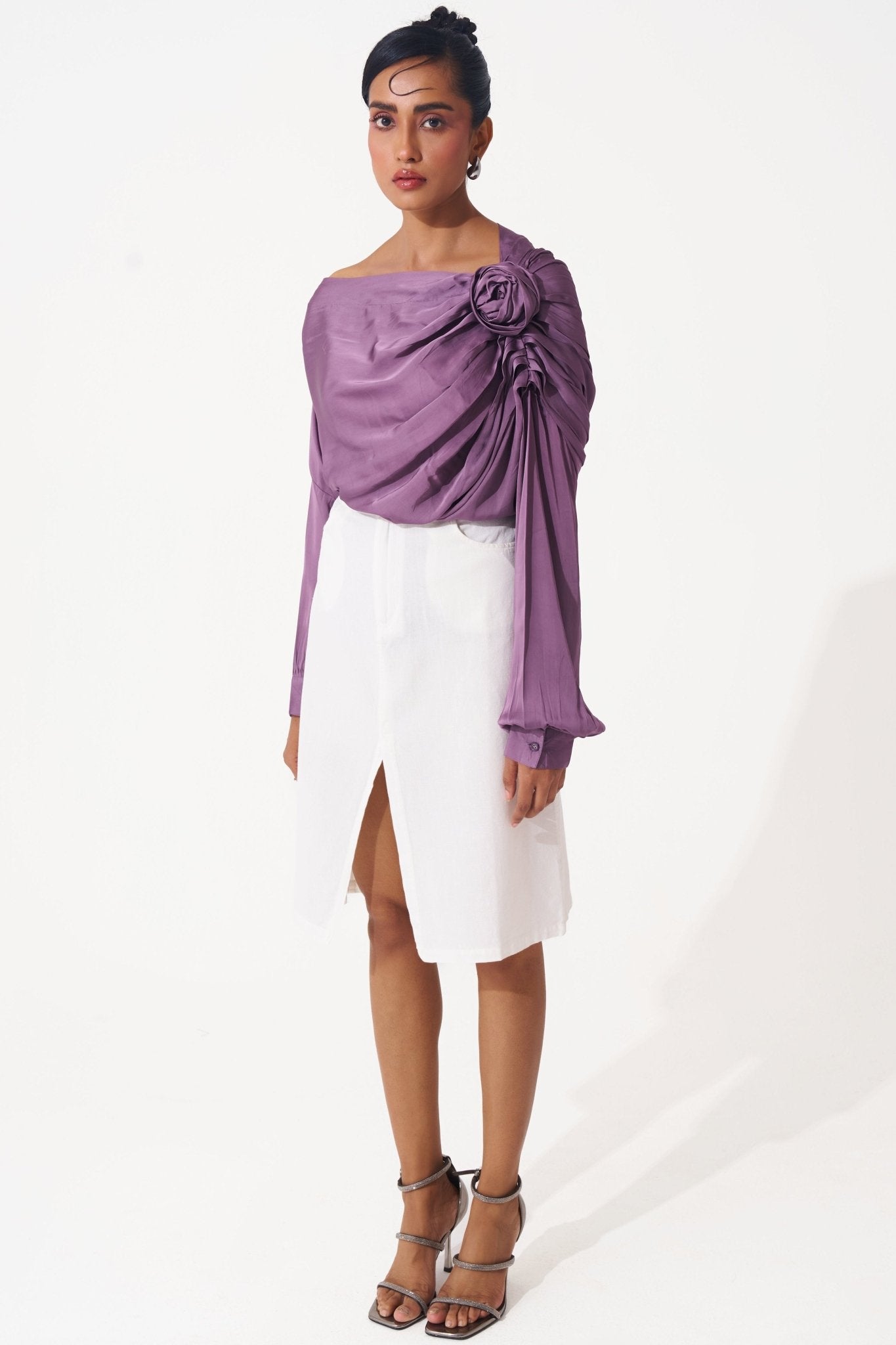 Stylera purple draped evening top with floral detail worn with white skirt and heels