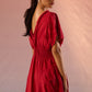 Stylera red Schiffli maxi dress with detailed embroidery and open back design on model
