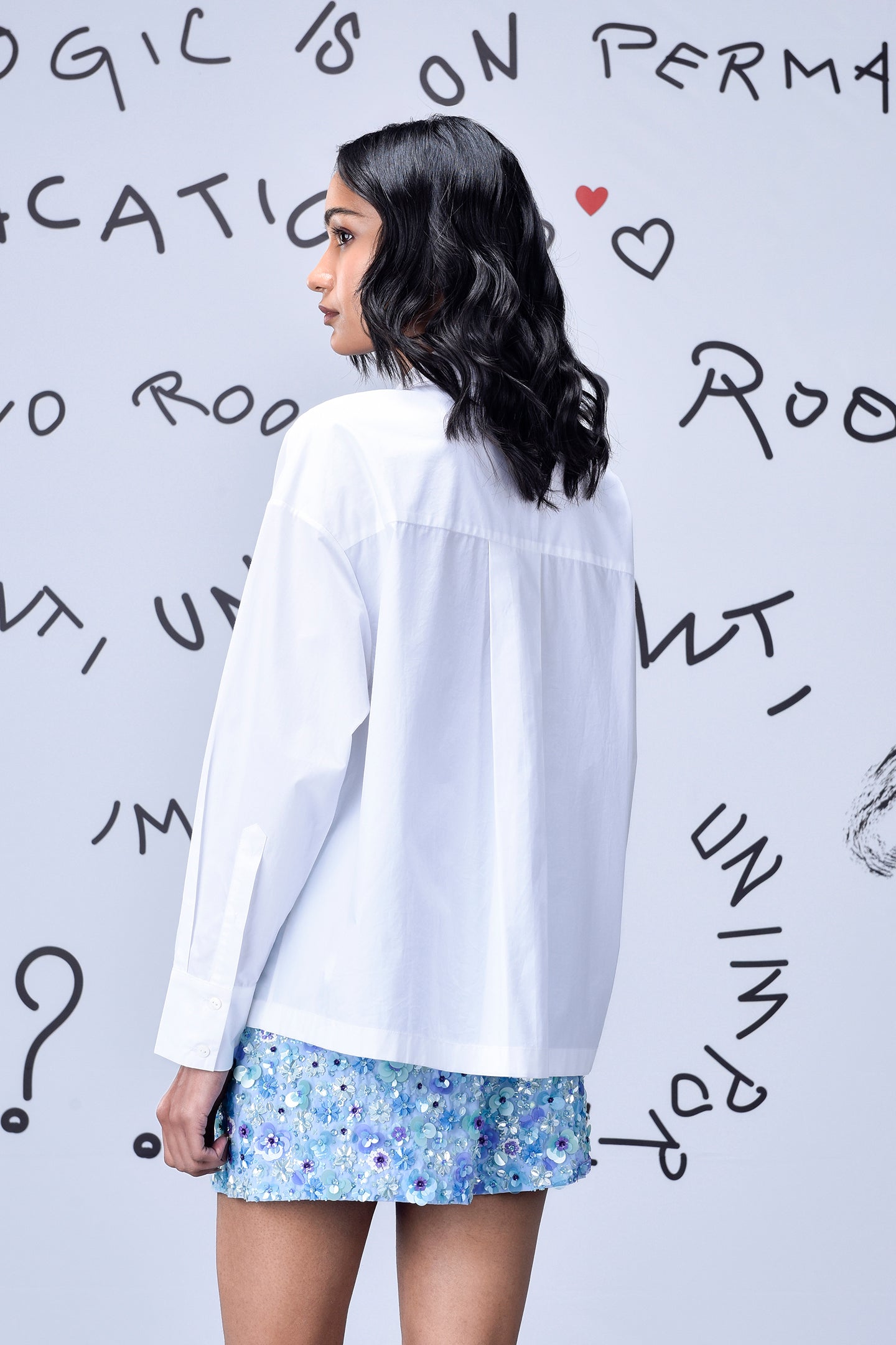 Woman wearing Stylera sequin heart shirt white long sleeve back view