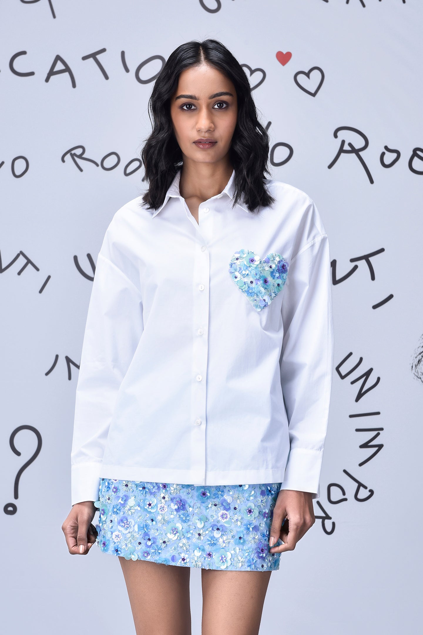 Stylera white sequin heart shirt with blue floral sequin skirt on model