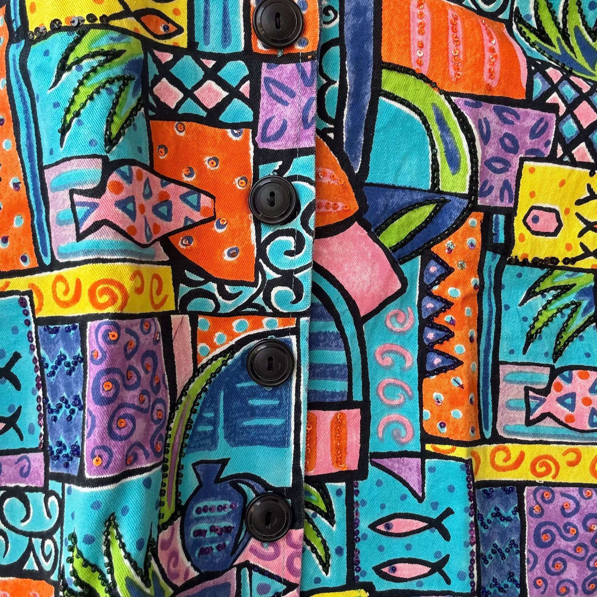 Close up of Stylera colorful patterned jacket with black buttons and tropical geometric print