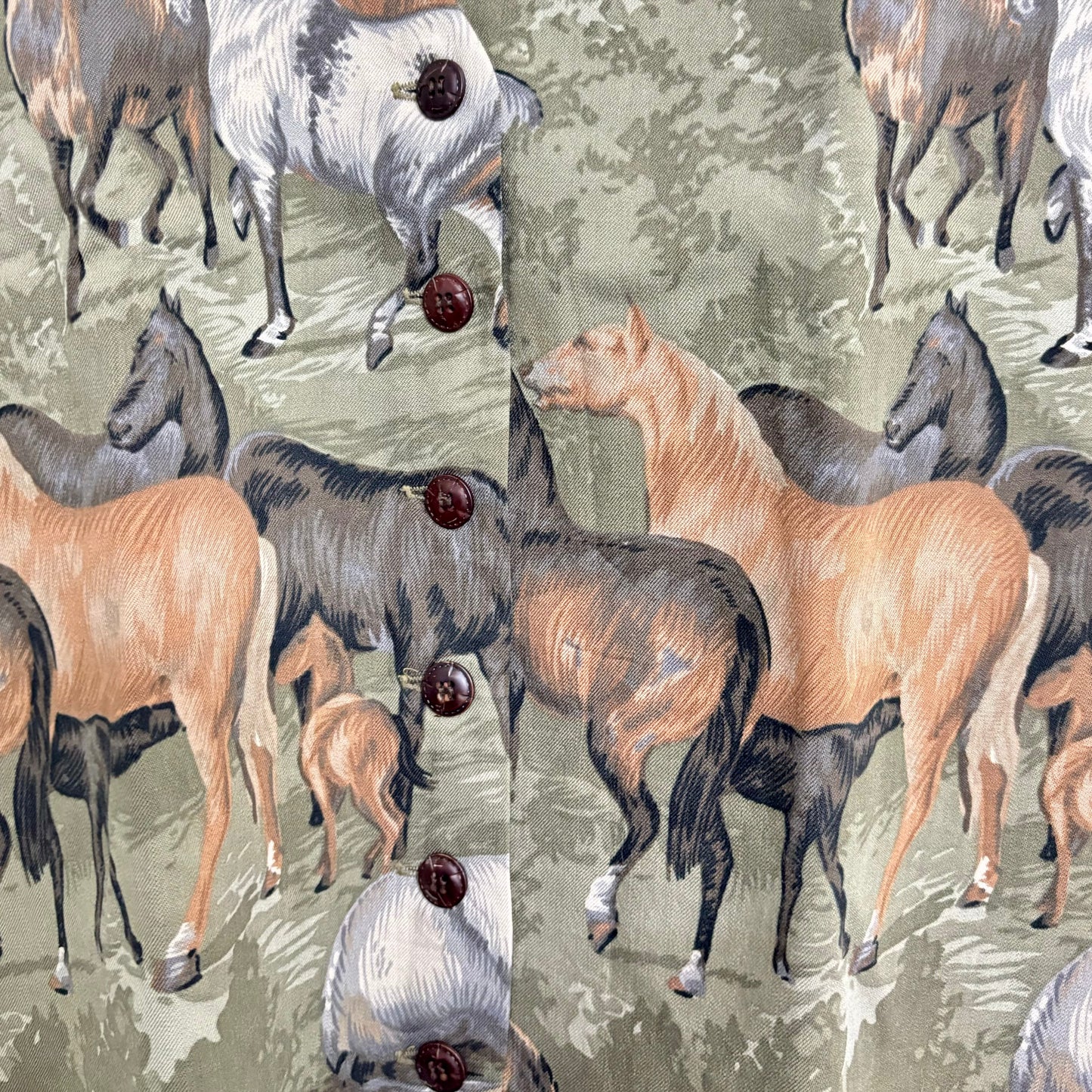 Stylera horse print vest close up showing multi horse pattern on green background with brown buttons