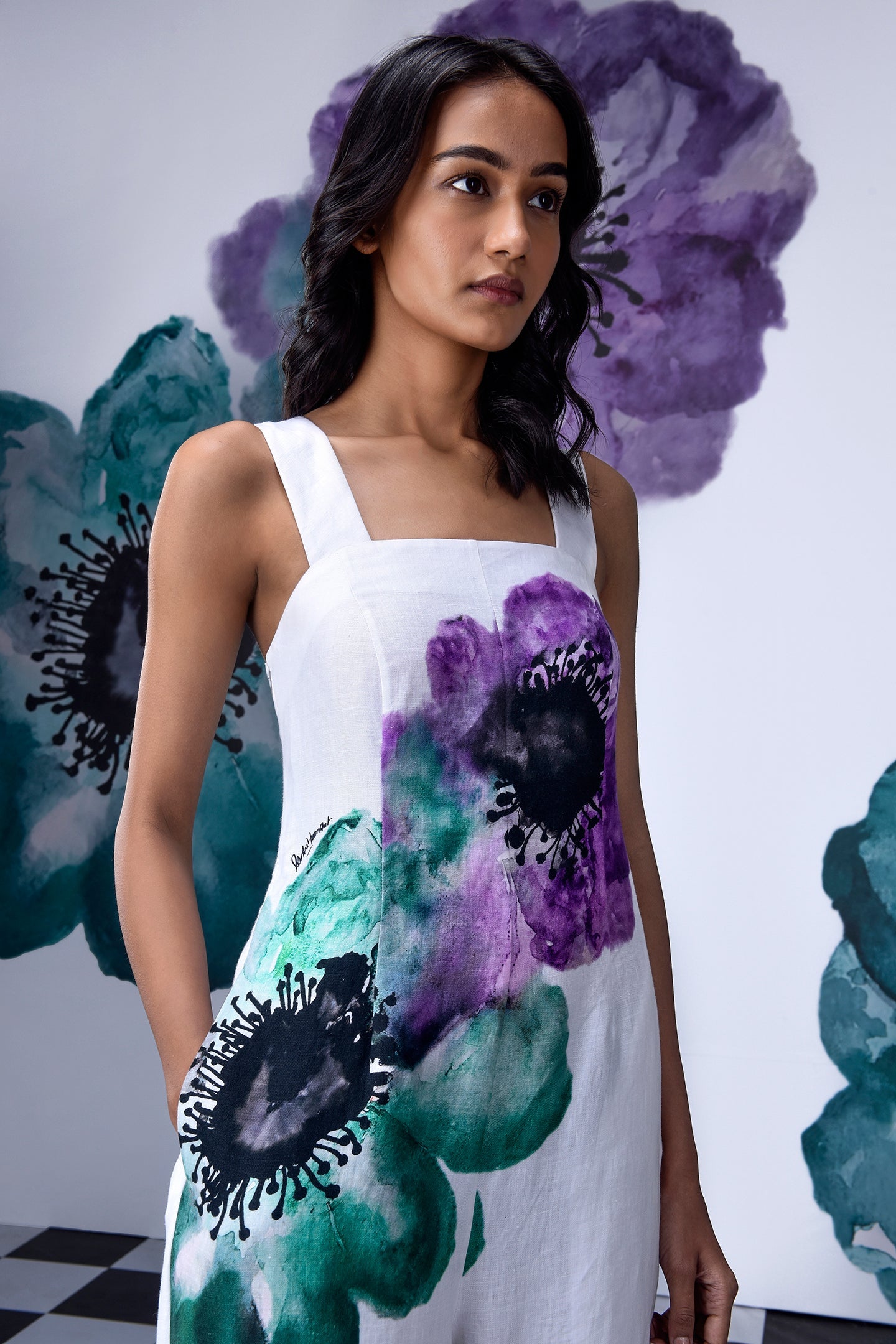 Model wearing white coral floral jumpsuit by Stylera with watercolor purple and teal floral print