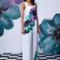 Model wearing Stylera white coral floral jumpsuit wide leg dungaree with bold teal and purple floral print