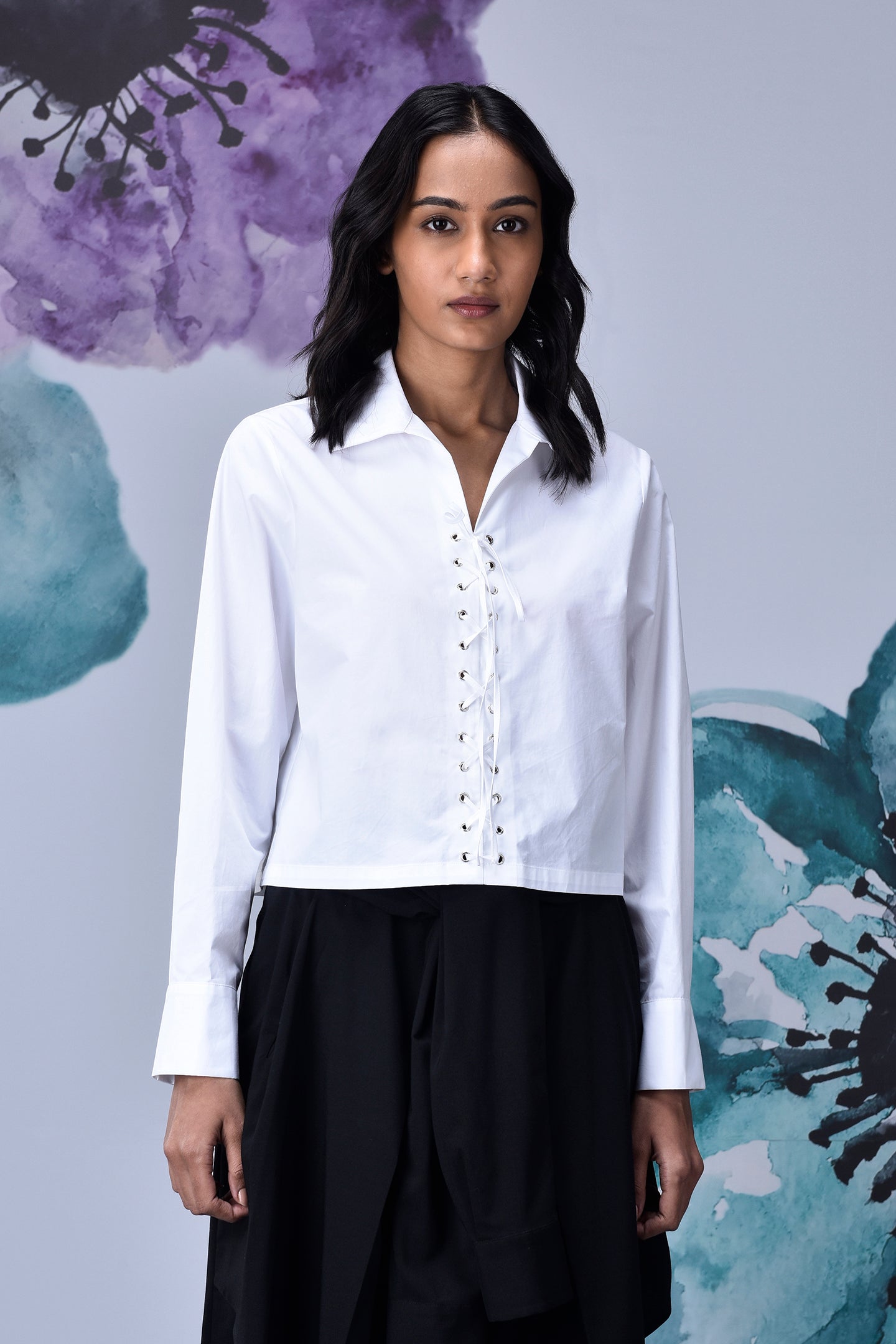 Stylera model wearing white cotton lace up shirt with collared neckline long sleeves and cropped hem