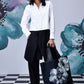 Model wearing Stylera white cotton lace up shirt paired with black wide pants and floral tote