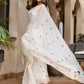Elegant white cotton saree with tassels adorned with colorful embroidery, perfect for festive occasions