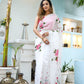 Elegant white floral saree for women with pink flowers, styled in a serene outdoor setting
