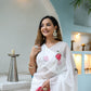 Elegant white organza saree for women with floral patterns, styled with traditional accessories