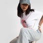 Woman wearing white oversized anime t-shirt for women paired with light blue jeans and denim cap