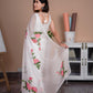 Elegant white saree with pink floral print draped gracefully, showcasing delicate flower designs