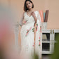 Elegant model showcasing a white saree with pink floral print, perfect for festive occasions