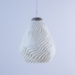 Stylish white sculptural hanging light with textured wave design for modern decor
