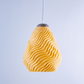 Stylish yellow pendant light in wavy design, perfect for modern decor, featuring a white sculptural hanging light