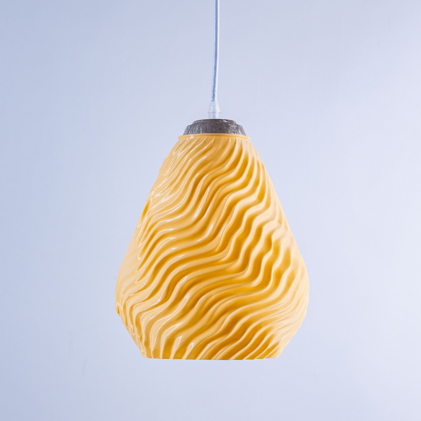 Stylish yellow pendant light in wavy design, perfect for modern decor, featuring a white sculptural hanging light
