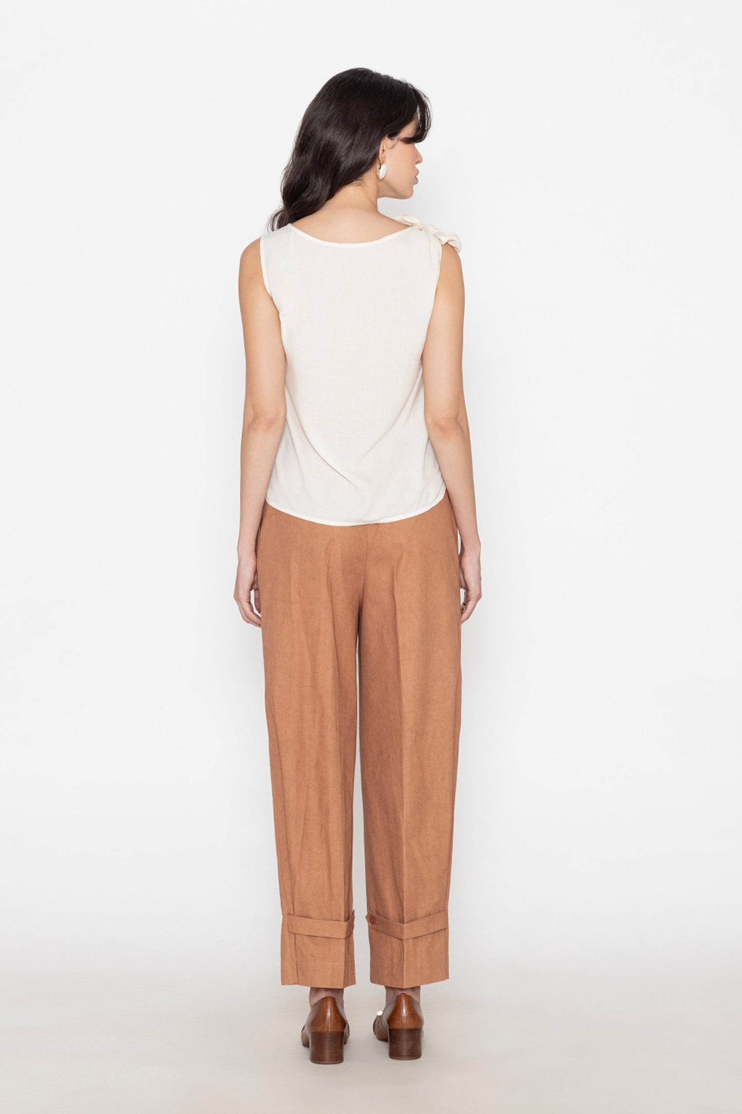 Back view of white sleeveless blouse paired with brown wide-leg pants