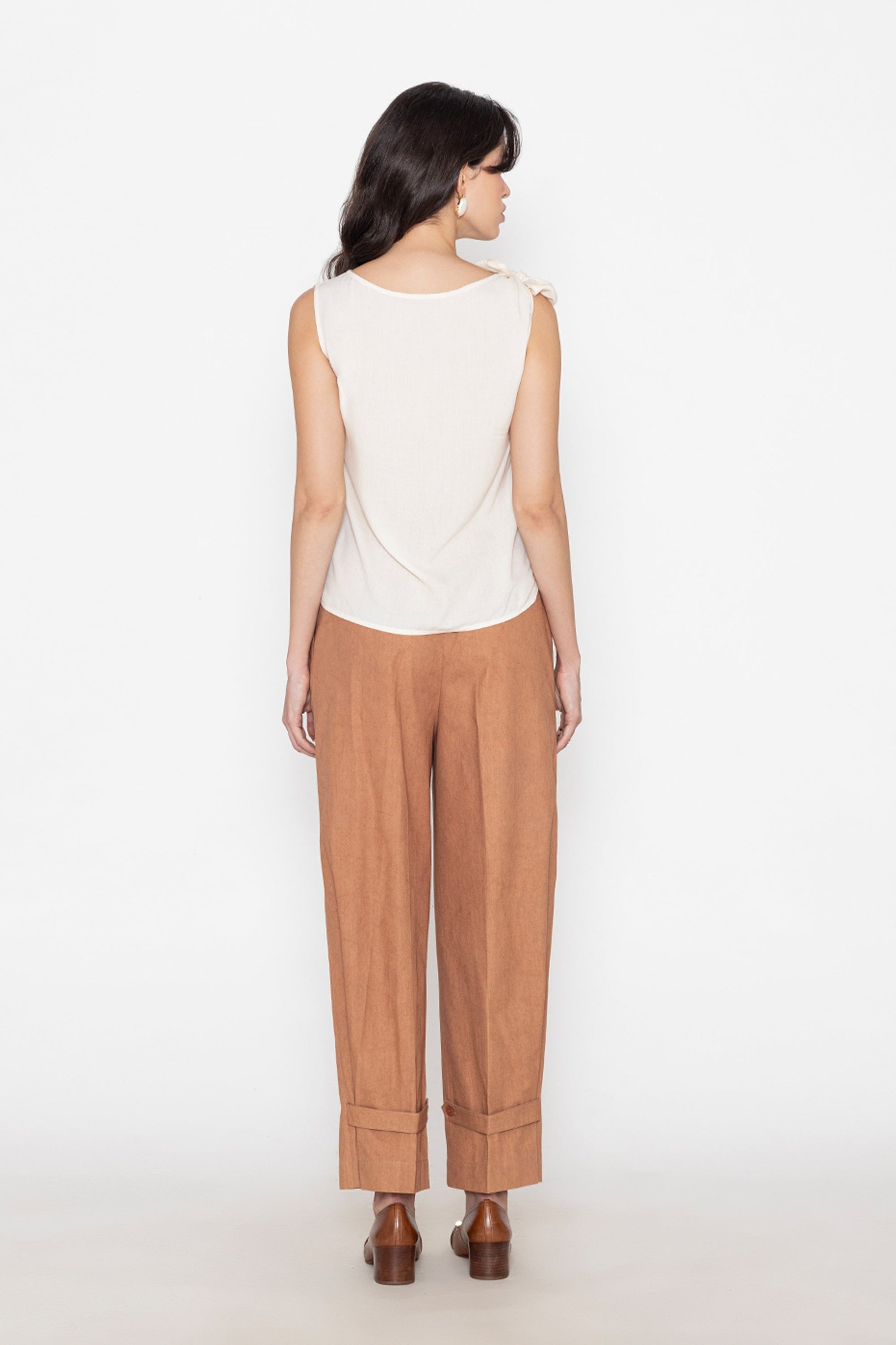 Back view of white sleeveless blouse paired with brown wide-leg pants