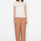 white sleeveless blouse with bow detail paired with brown pants