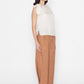 white sleeveless blouse with shoulder tie detail paired with brown wide-leg pants