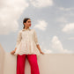 Model in a white tunic top casual wear paired with pink pants for a stylish look