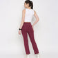 Back view of a model wearing a white twisted crop top paired with maroon activewear pants from Stylera
