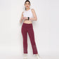 Model wearing a white twisted crop top paired with burgundy leggings for a stylish active look