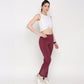 Model wearing a white twisted crop top paired with maroon workout pants for an active look