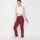 Model wearing a white twisted crop top with maroon gym pants featuring embellishments