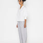 Stylera white v-neck blouse for women with balloon sleeves paired with light gray pants