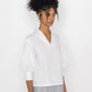 Stylera white v-neck blouse for women with puff sleeves styled with gray pants