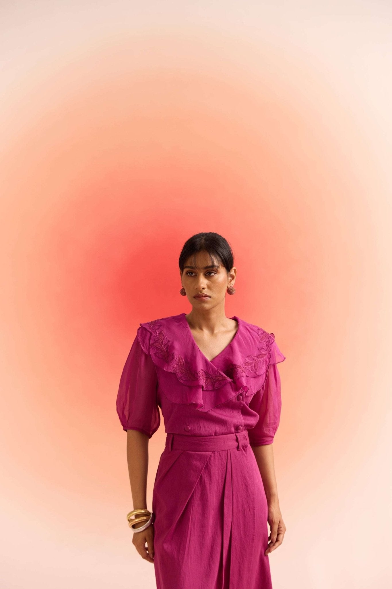 Stylera woman wearing a wine embroidered scalloped top with puff sleeves and ruffle details