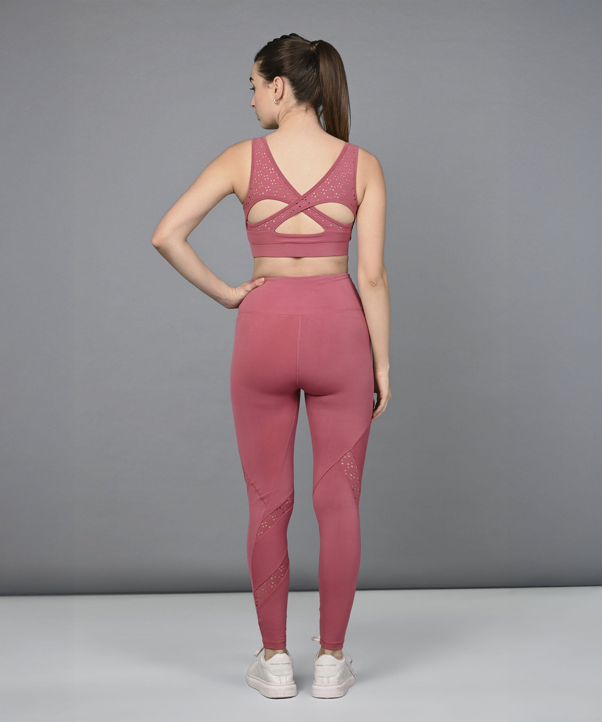 Back view of a women's mesh workout top by Stylera, paired with matching leggings for fitness enthusiasts.