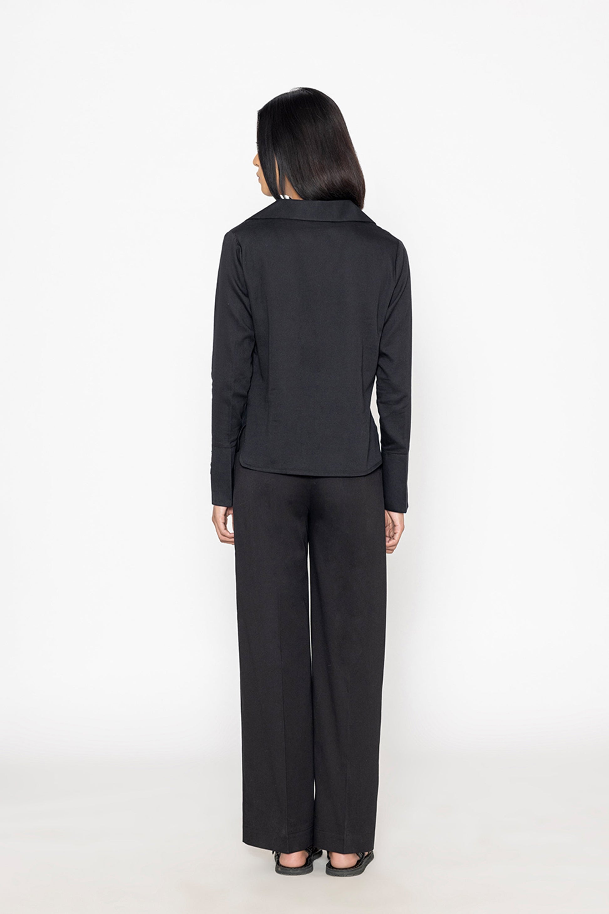 Stylera women's black wide leg trousers shown from the back worn with a black long sleeve top