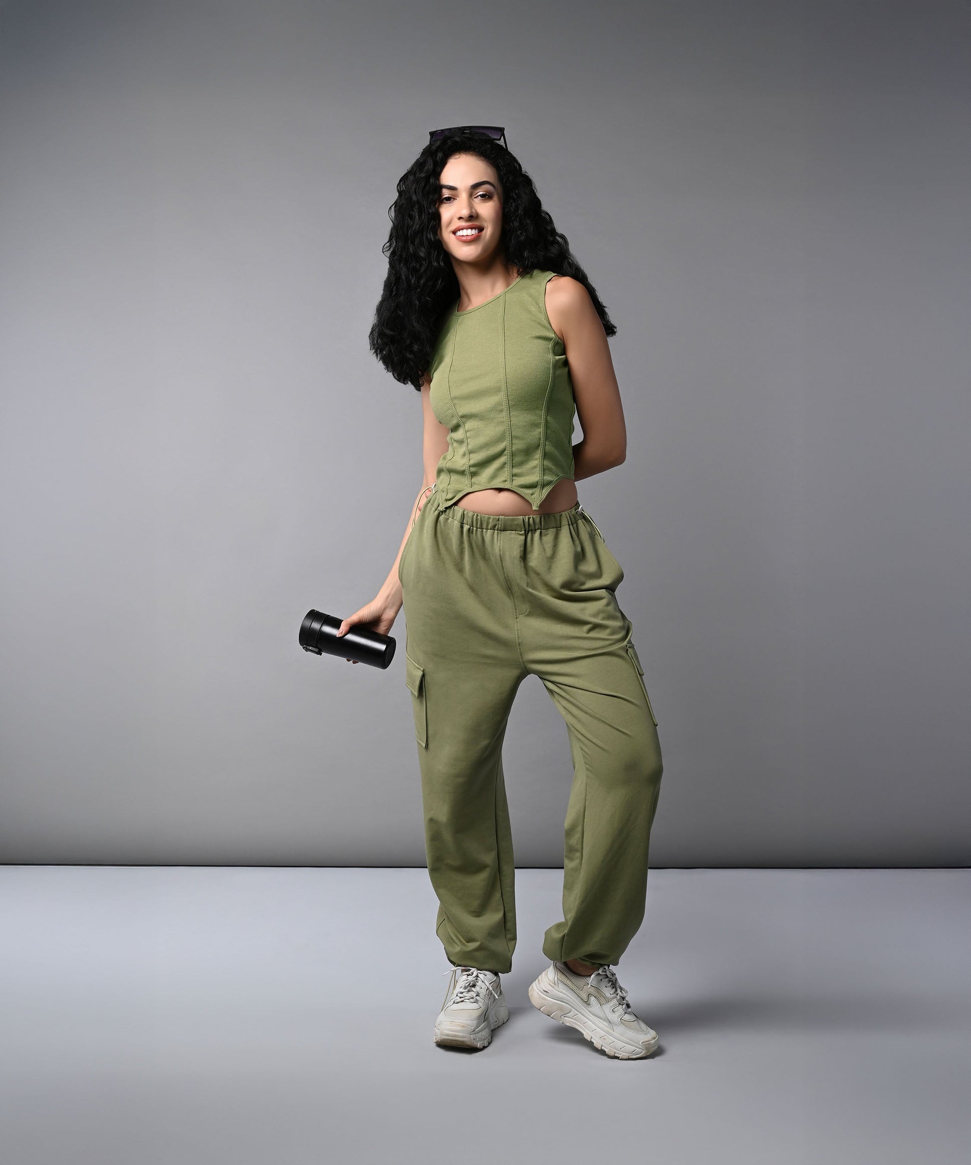 Model in women's cargo parachute pants with crop top, styled in olive green for a trendy look