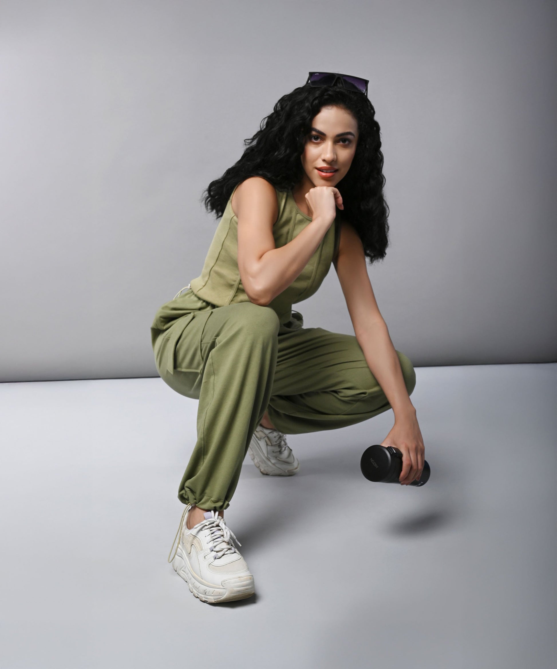 Model wearing women's cargo parachute pants with crop top in olive green, styled for casual fitness looks