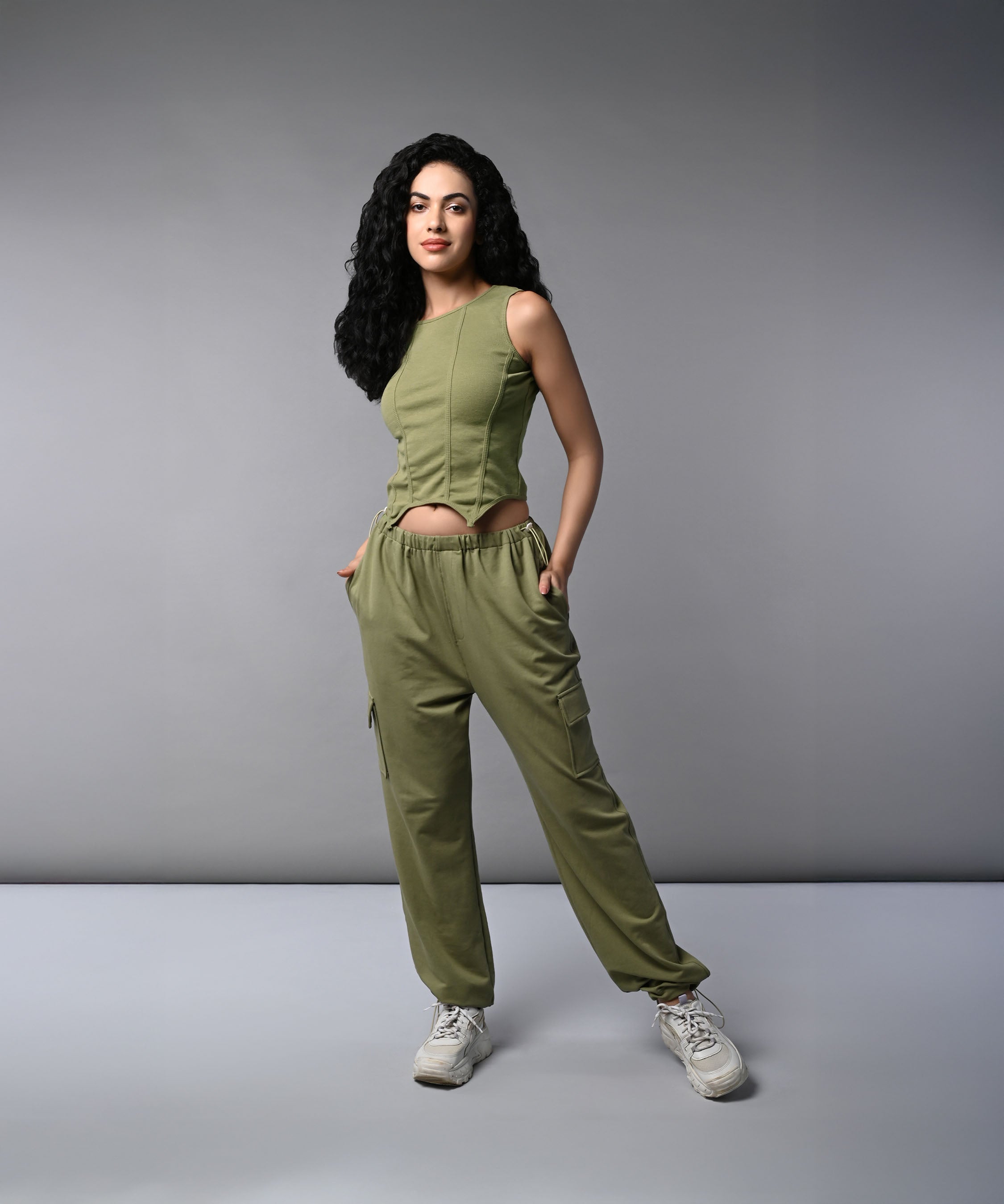 Model wearing women's cargo parachute pants with crop top in olive green for a stylish casual look