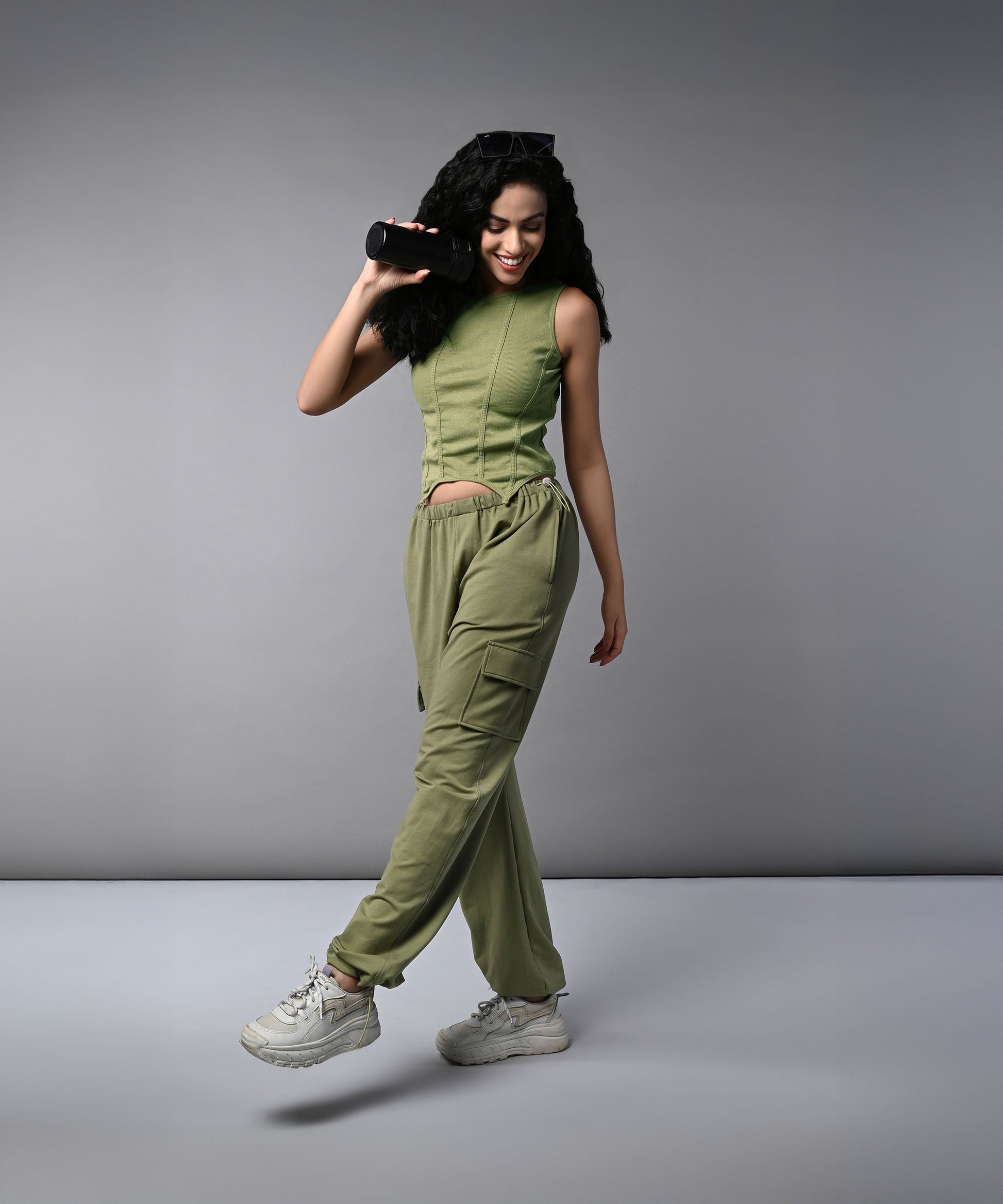 Stylish model wearing women's cargo parachute pants with crop top in olive green color
